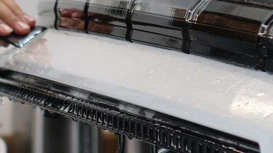 Close-up of clear paint protection film being applied to a white E.V. Hummer