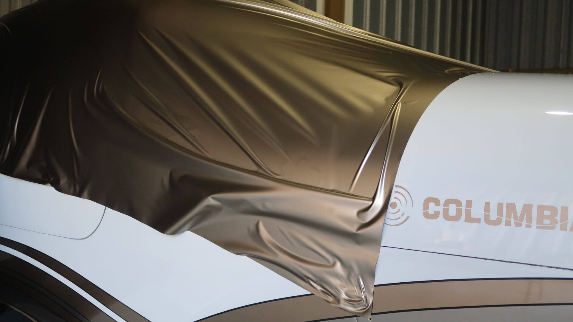 Gold vinyl wrap being applied to a Columbia aircraft at Falcon Field Airport