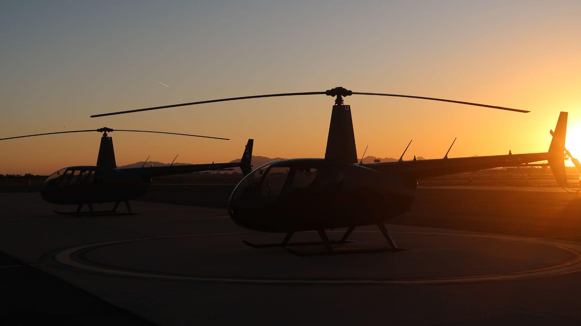 Two Robinson helicopters at sunset in Arizona