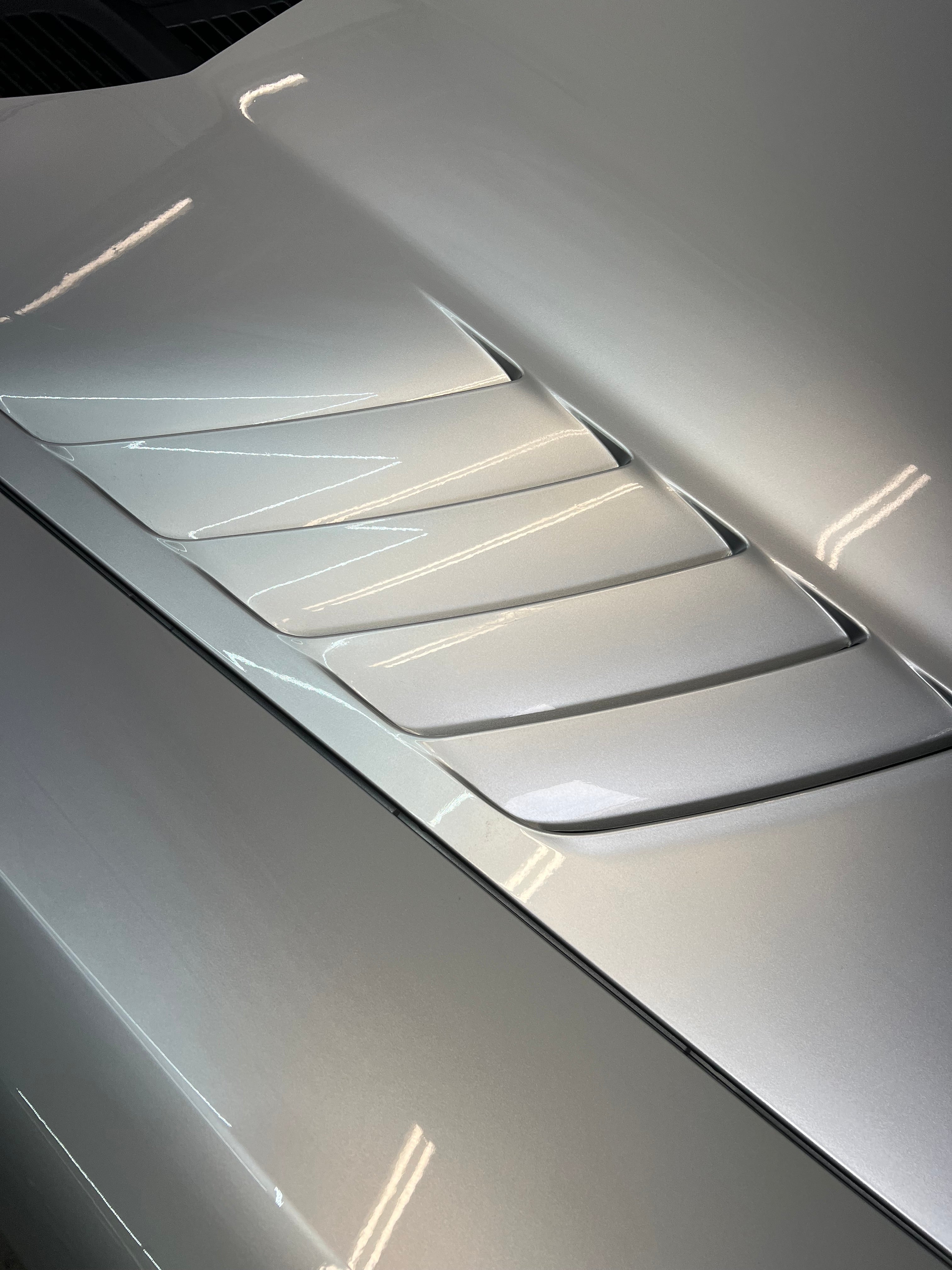 Close-up of gloss paint protection film installed on the hood of a silver Dodge Viper